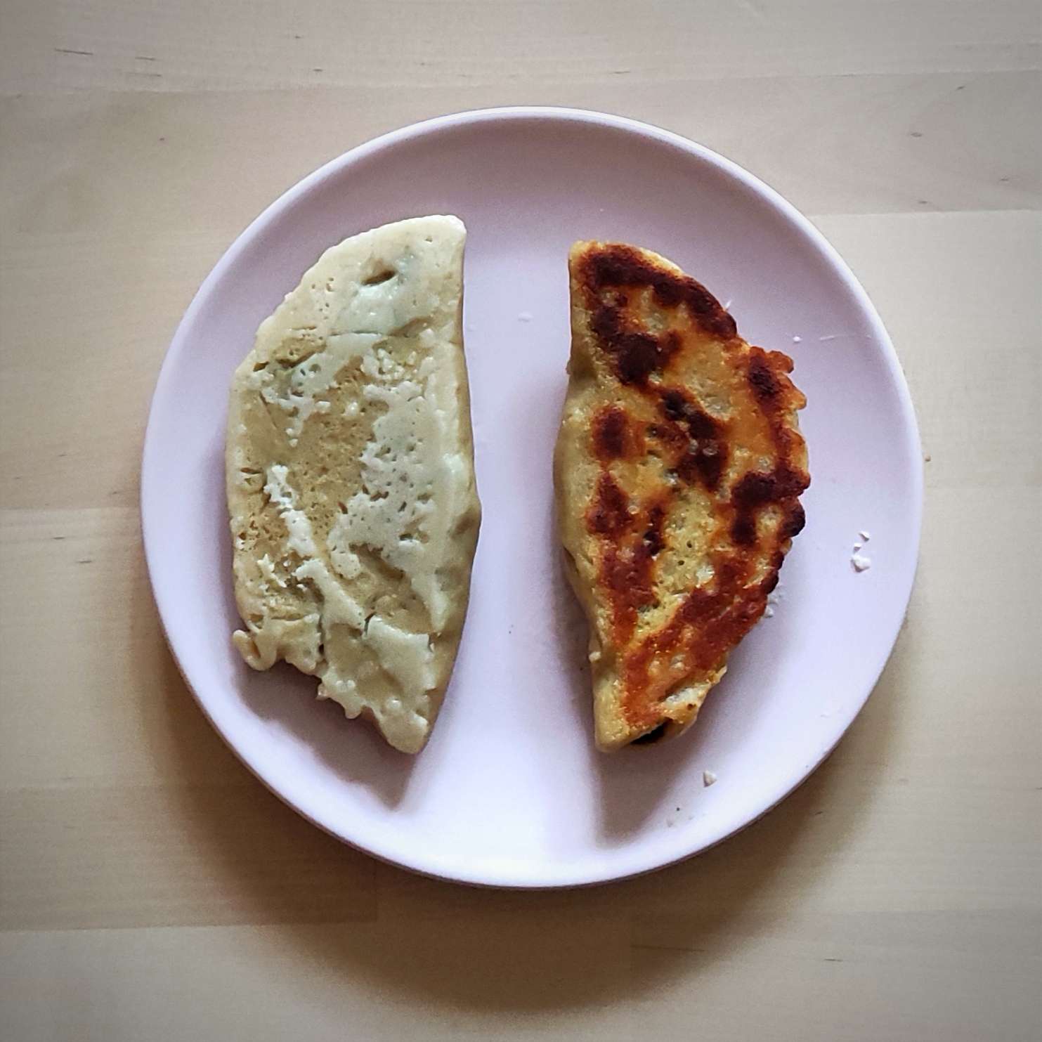 Photographie d'un gyoza cuit à la vapeur (à gauche) et d'un autre ensuite grillé à la poêle (à droite).