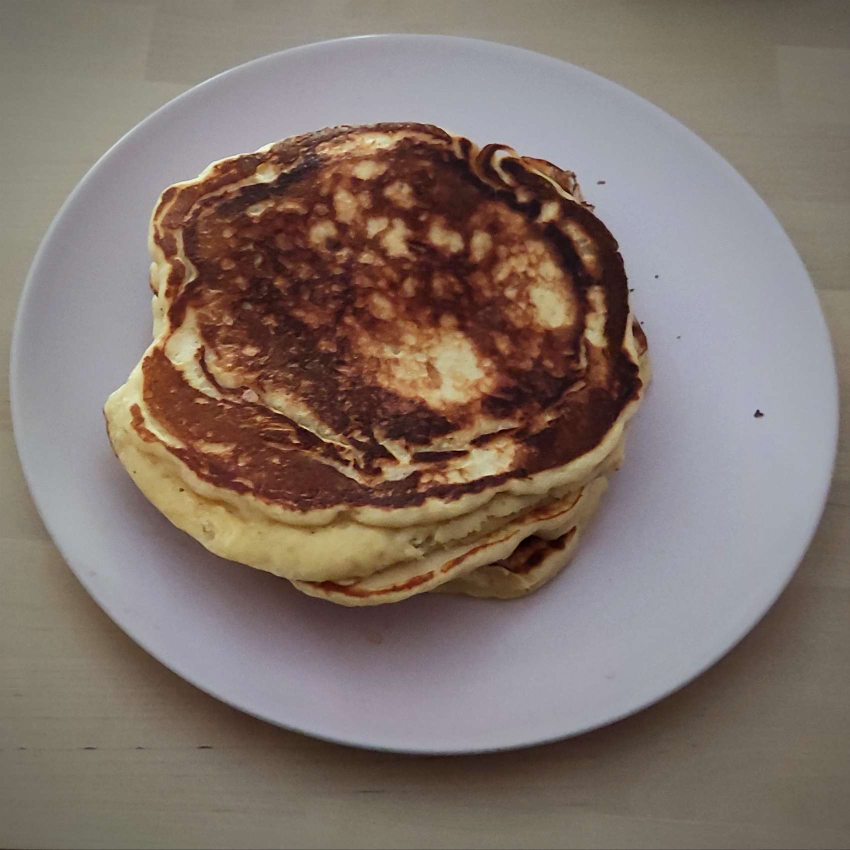 Photographie de trois pancakes épais empilés.